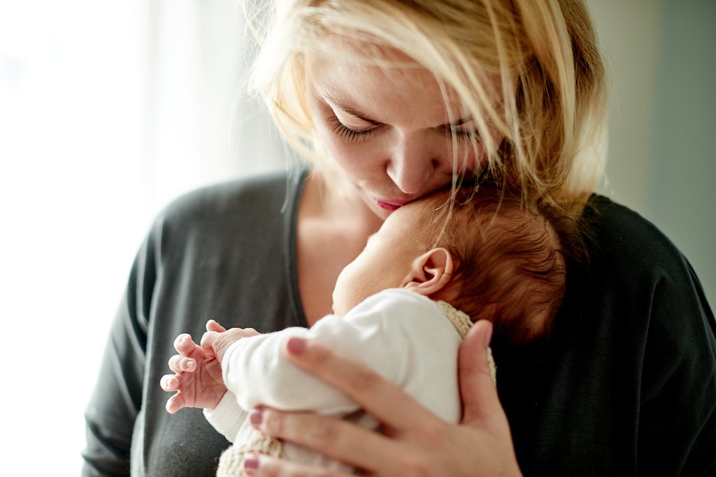 Maman tenant son bébé dans ses bras et l'embrasssant